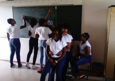 Groupe d'étudiants en Guadeloupe collaborant joyeusement au tableau noir, illustrant l'esprit communautaire des actions culturelles éducatives sur l'île.