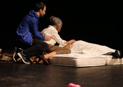 Des acteurs en pause durant un cours de théâtre, capturant un moment de complicité et de réflexion qui illustre l'atmosphère des ateliers de théâtre en Guadeloupe